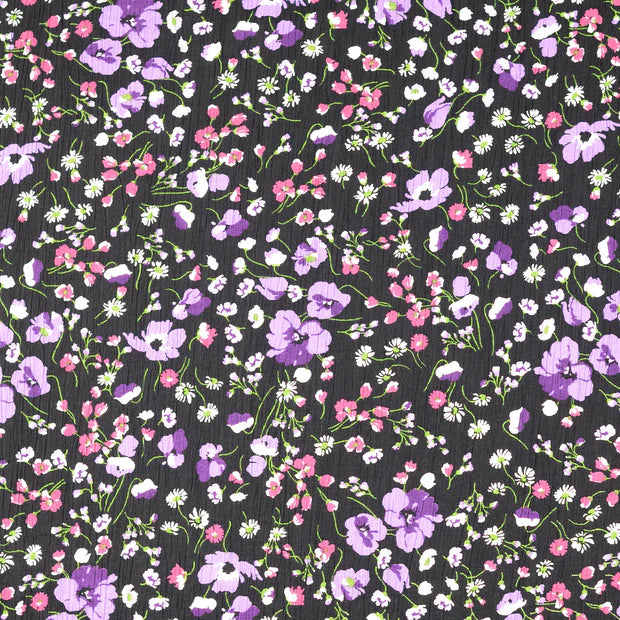 Viscoza creponata cu imprimeu floral delicat, pe fundal negru cu flori mici in nuante mov fucsia si alb latime 136/138 cm 75%VI 25% poliamida