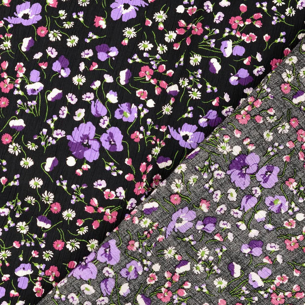 Viscoza creponata cu imprimeu floral delicat, pe fundal negru cu flori mici in nuante mov fucsia si alb latime 136/138 cm 75%VI 25% poliamida