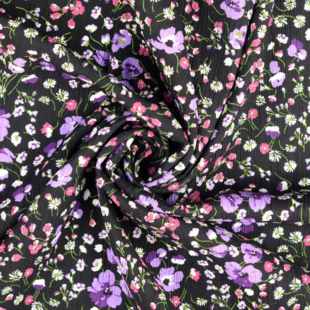 Viscoza creponata cu imprimeu floral delicat, pe fundal negru cu flori mici in nuante mov fucsia si alb latime 136/138 cm 75%VI 25% poliamida